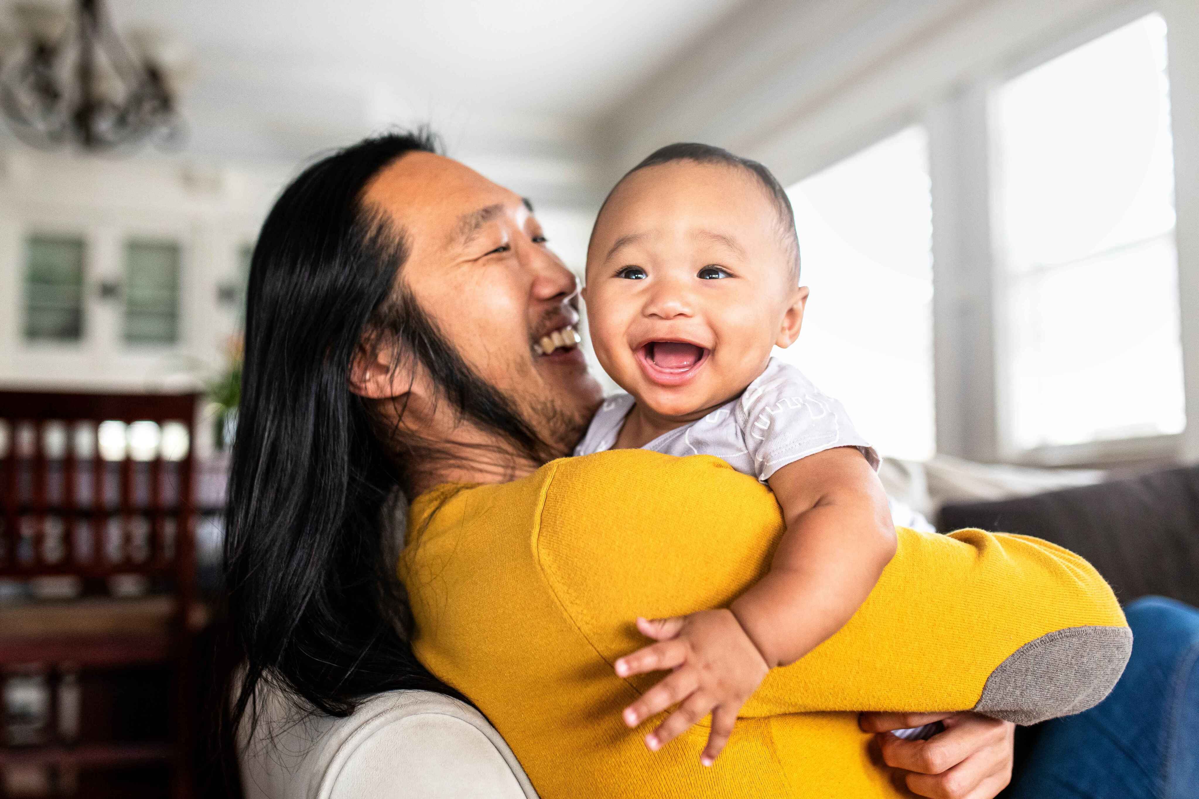 Asian American father hugging his son