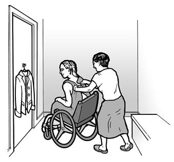 A woman using a wheelchair is trying on clothes in a dressing room and a friend is helping her