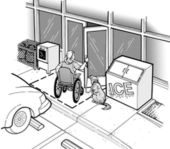 A woman using a wheelchair, with a service animal, is opening the door to a convenience store.  The store's ice box and newspaper sales box are on the sidewalk, but are away from the door, so they do not block her entrance.